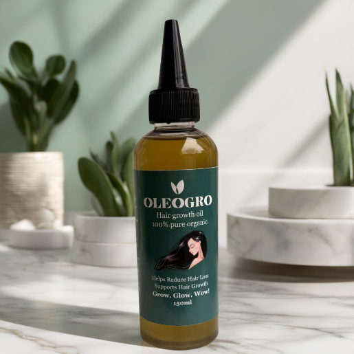 OLEOGRO hair growth oil bottle on a marble surface with plants in the background