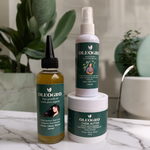 Three Oleogro hair care products on a marble surface with plants in the background